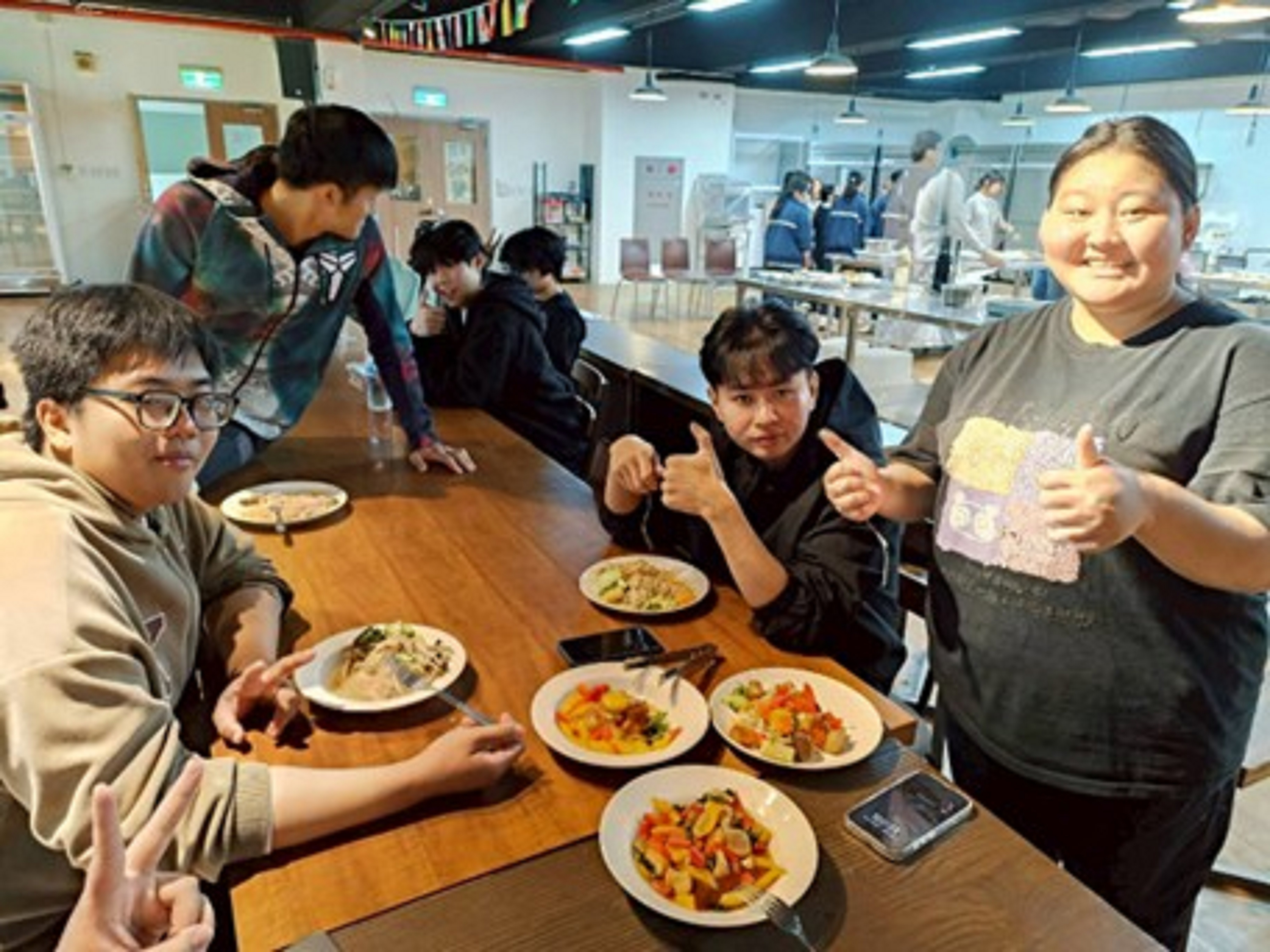 學生享用胡麻菌菇涼麵、醬香素扇貝、素食塔香三杯雞