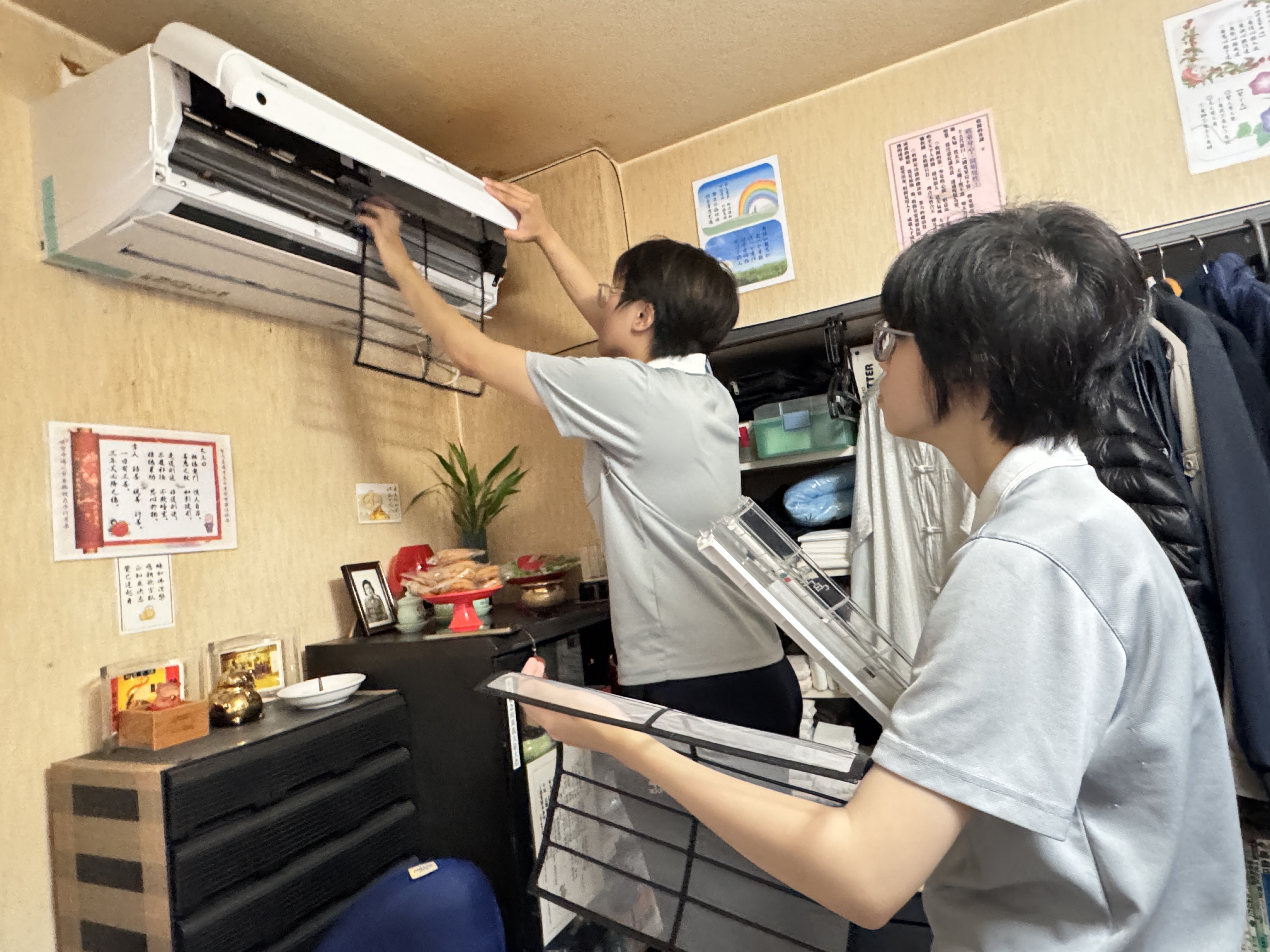 志工細心拆卸冷氣濾網與面板清洗,提升居住環境品質